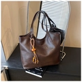 Dark brown leather tote bag with woven bead charm in a minimalist studio setting - Coffee with Pendant