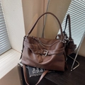 Brown lychee leather tote bag with silver buckle and thin strap in minimalist room - Coffee