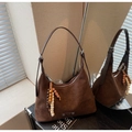 Detail of dark brown matte suede hobo bag featuring ethnic wooden bead tassel and metal buckle - Coffee with Pendant