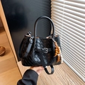 Black woven leather bucket bag with adjustable shoulder strap and wooden bead charm - Black with Pendant