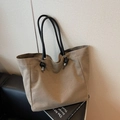 Minimalist khaki canvas tote bag with thick black rope handles on a leather sofa - Khaki
