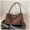 Detail of suede boston bag with leather handles and golden zippers on a black texture - Brown
