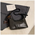 Detalle de bolso hobo gris vintage con colgante de perro sobre fondo de traje formal - Negro con colgante