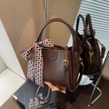 Brown vintage leather bucket bag with top handle and patterned silk scarf accent - Coffee