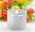 Close-up of a white reindeer and snowflake cutout candle holder with warm LED light - White