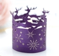 Macro detail of purple laser-cut paper candle wrap with reindeer and snowflake motifs - Dark Purple