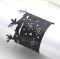 Detail showing matte black laser-cut napkin ring with reindeer and snowflake design - Black Khaki