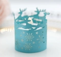 Macro shot of laser-cut teal glitter paper tea light wrap with reindeer and snowflakes - Tiffany Blue