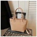 Beige Tragetasche mit Webstruktur, Knotengriffen und Schultergurt auf Koffer - Khaki