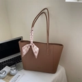 Brown lychee leather tote bag with a houndstooth scarf handle in an office setting - Biscuit