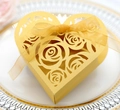 Detail of laser-cut rose patterns on a heart-shaped gold gift box with a silk ribbon - Gold