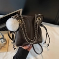 Dark brown leather drawstring bucket bag with gold chain and white plush pompom charm - Black