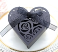 Close-up of black heart-shaped gift box with laser-cut rose patterns and silk ribbon - Black