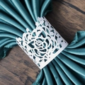 Detailed macro of laser-cut white rose paper napkin ring with emerald green satin - White