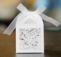 Detailed view of white laser-cut rose gift box with elegant organza ribbon on wood table - White