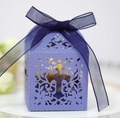 Detail of purple laser-cut candy box featuring hollow cross and floral pattern with blue ribbon - Sapphire Blue