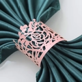 Detail of pink laser-cut paper napkin rings with rose design on green satin fabric - Pink