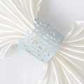 Detailed close-up of light blue laser-cut floral paper napkin ring on white satin fabric - Pearl Pale Blue