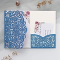 Dettaglio dell'invito di nozze blu navy tagliato al laser con fiori e carta RSVP - Blu Reale
