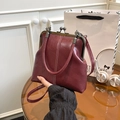 Détail du sac vintage bordeaux avec doubles coutures blanches et fermoir métallique - Bordeaux