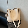 Creamy beige bucket bag with lychee texture and cute brown monster plush charm - Off White
