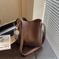 Deep brown lychee texture bucket bag with cute fur ball charm for daily office commute - Brown