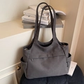 Gray canvas tote bag featuring front zipper pocket and side slots on corduroy surface - Dark Brown