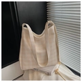 Detail of beige gingham tote bag featuring a floral pearl pendant on a modern art book - Off White