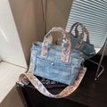 Blaue Denim-Tragetasche mit floral bestickten Griffen und verstellbarem Schultergurt - Hellblau