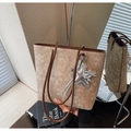 Detail of floral tote bag with brown leather straps and silver star pendant accessory - With Charm / Brown
