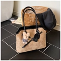 Détail du sac cabas en suède avec garniture en cuir et breloque ours sur marbre - Khaki avec Pendentif