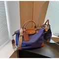 Detalle del bolso tote de nailon azul con ribete de cuero y correa bordada geométrica - Azul