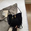 Close-up of black suede bohemian fringe bag with elegant golden twist-lock decoration - Black