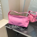 Pink faux leather bucket bag featuring silver rivet accents and a sleek metal chain strap - Pink