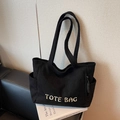 Minimalist black corduroy tote bag with white embroidery and side storage pockets - Black