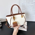 Fashionable cream leather bucket bag with brown contrast trim and mini charm accessory - White with Pendant