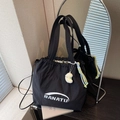 Black nylon tote bag featuring white BANATU logo and decorative plush pendant - Black with Pendant