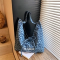 Blue leopard print tote bag with bow tie and embroidery on a wooden table surface - Denim Blue