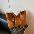 Brown suede tote bag with colorful beaded tassel on a stack of art design books - Brown with Pendant