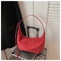 Detail of red oversized hobo bag on a silver suitcase with a stylish knotted strap - Red