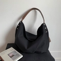 Detail of black canvas hobo bag with pleated bottom and brown leather shoulder strap - Black
