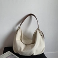 Detail of minimalist canvas hobo bag with metal rivets and premium brown leather strap - White