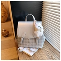 Close-up of stylish grey backpack with plaid bottom, embroidery, and cute puppy charm detail - Silver