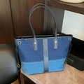 Sac cabas en denim patchwork avec lanières en cuir et détails coulissants sur table en marbre - Bleu clair