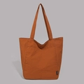 Detailansicht der Nylon-Tragetasche in Karamell mit Fronttasche und Markenetikett - Orange