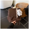 Close-up of vintage brown plaid backpack with faux leather flap and cute bear charm - Brown