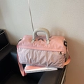 Pink fitness travel bag with white grid pattern and gray handles on a sofa - Pink