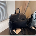 Détail d'un sac à dos noir en similicuir avec bouton pression et cordons latéraux - Taille unique / Noir