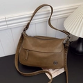 Vintage brown leather crossbody square bag with adjustable strap in minimalist home setting - Khaki