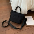 Detail der schwarzen Canvas-Tragetasche mit Vordertaschen-Design und langem Schultergurt - Schwarz